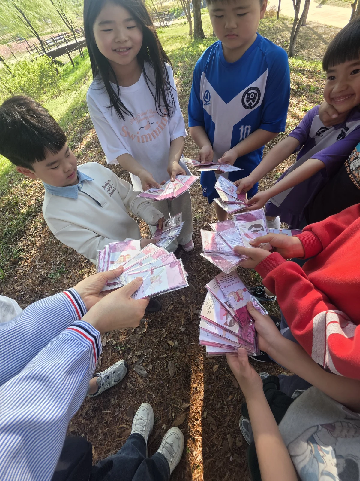 야외에서 선생님과 어린이들이 모여 활동하는 모습